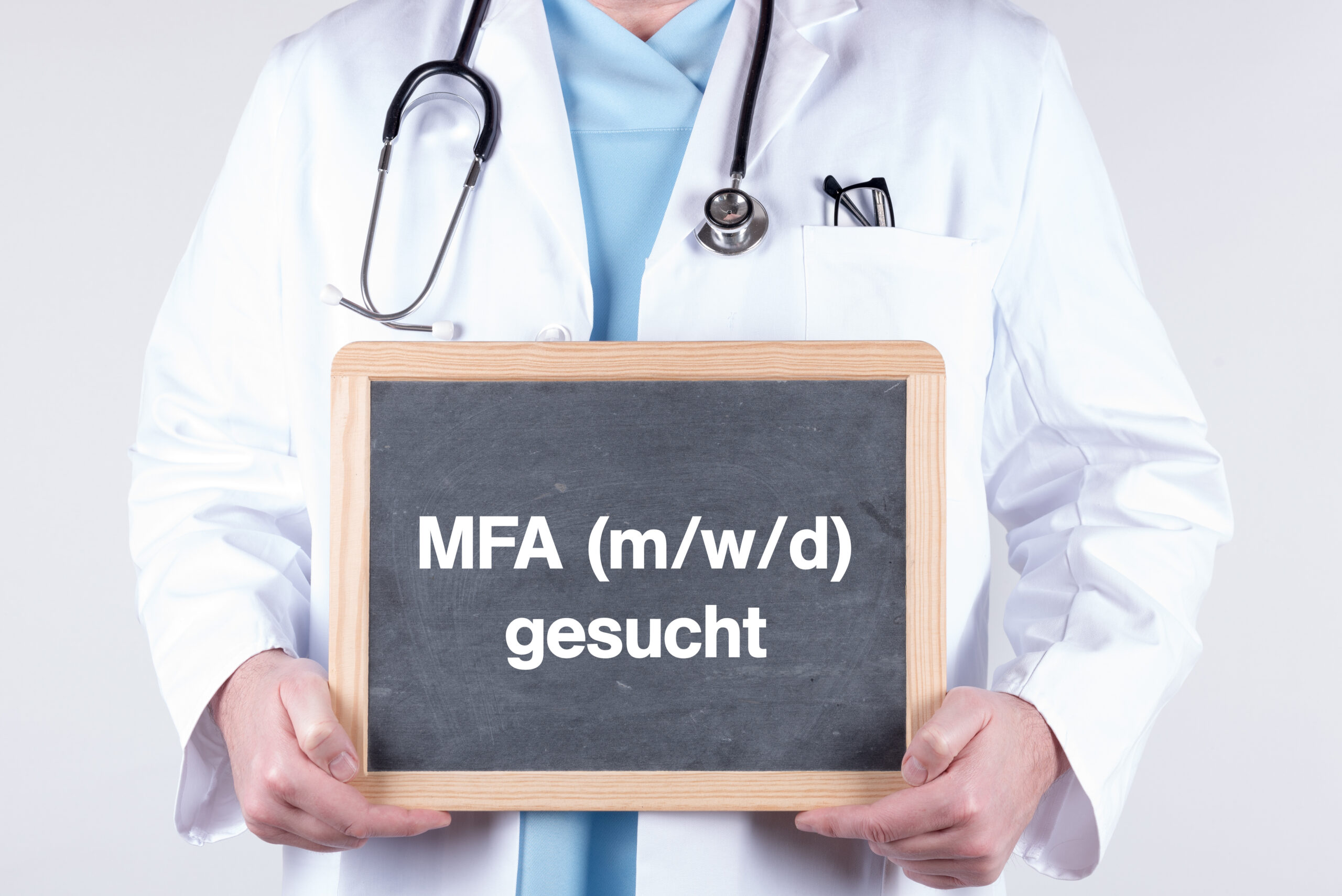 Arzt mit einer Tafel auf der MFA gesucht steht