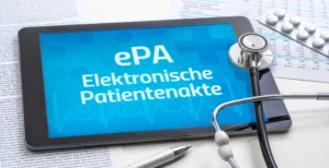 Tablet-PC mit dem Text "ePA Elektronische Patientenakte" auf dem Display, umringt von Medizin-Utensilien wie Tabletten, Stethoskop und medizinischem Befund.